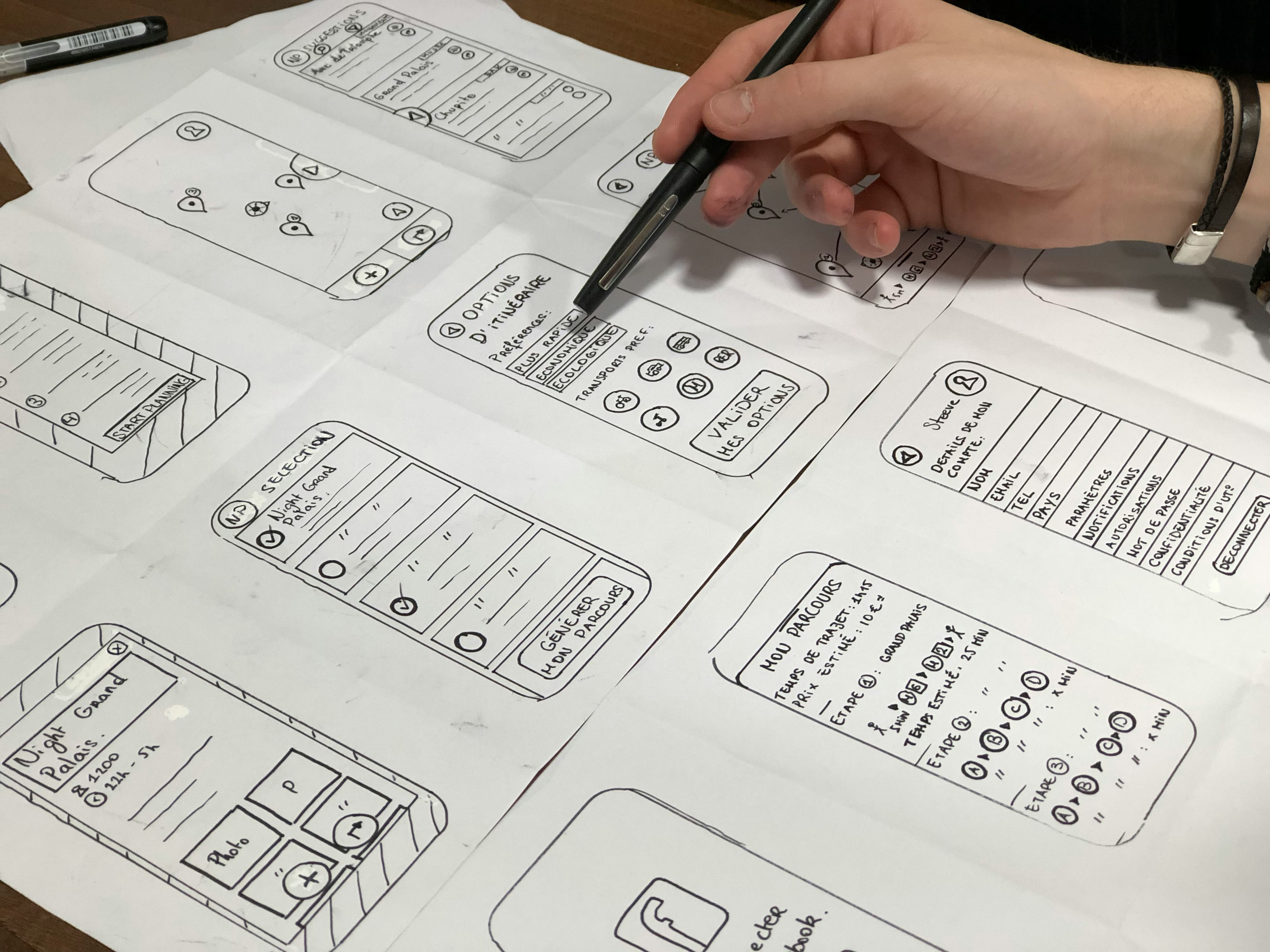 Designer sketching mobile app wireframes on paper during discovery phase
